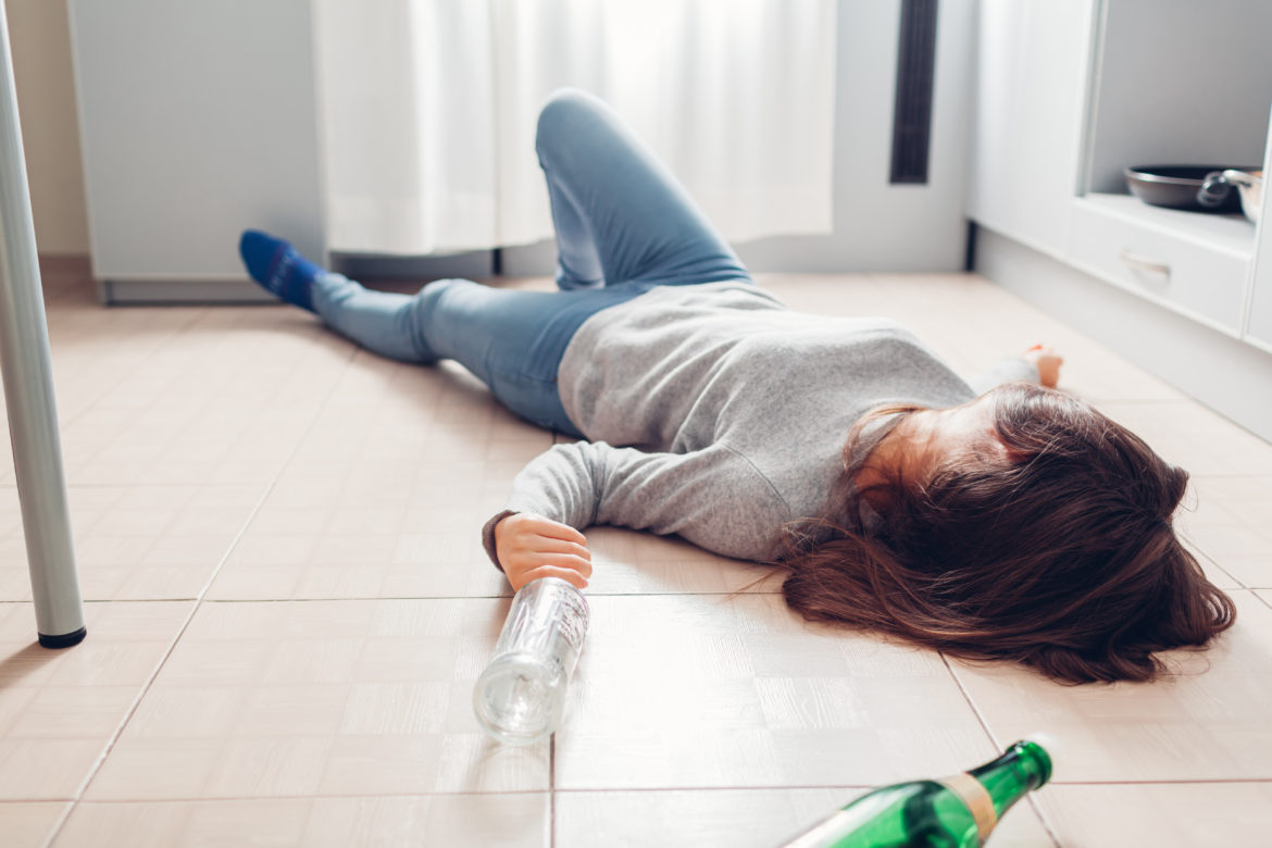 A woman passed out on the floor with bottle nearby, to show dangers of muscle relaxers and alcohol and treatment at Circle of Hope treatment los angeles